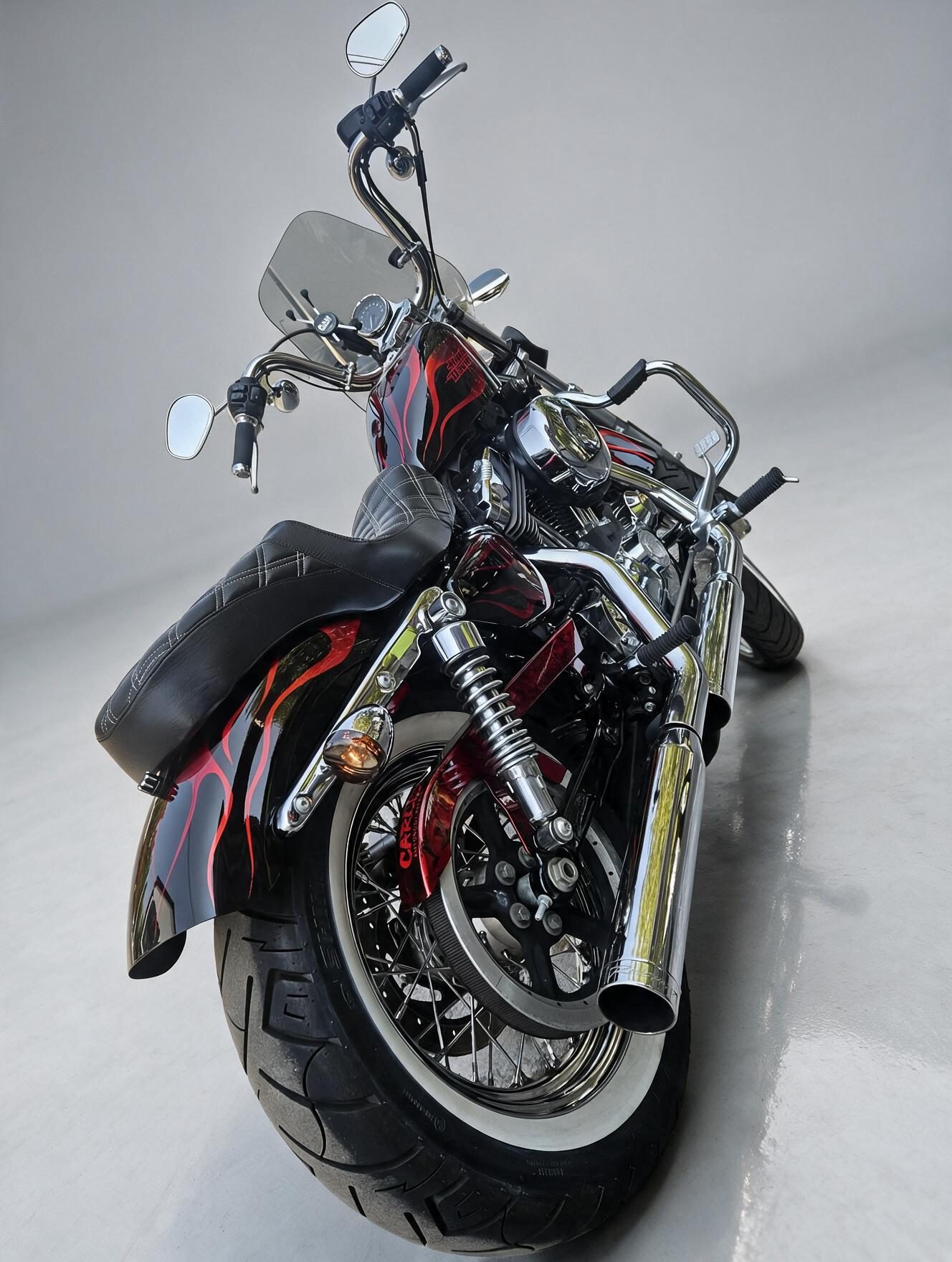 Front view of a custom-painted Harley Davidson motorcycle with red flame details